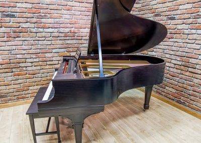 side view of high luster, black mahogany piano